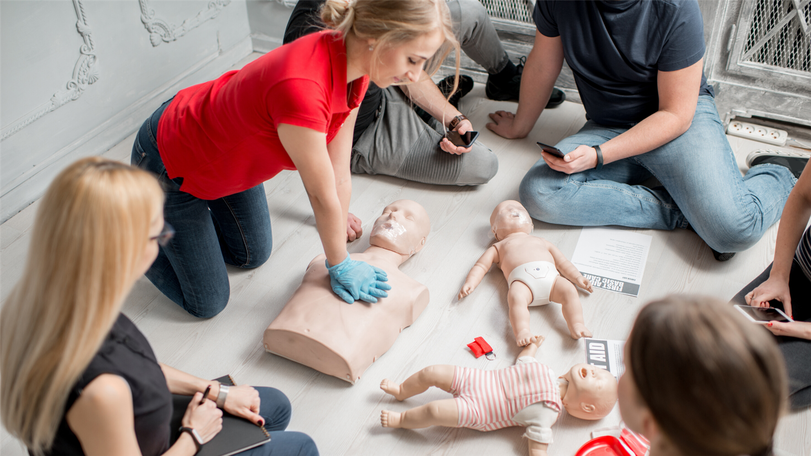 Student practices chest compressions on dummy